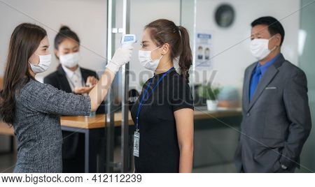 Woman Officer Use Scaner Thermometer Check A Temperature Of All Person Before Pass To Office Inside 