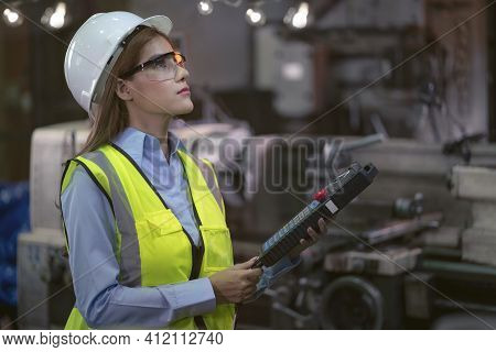 Female Factory Worker Inspecting Production Line At Machine Making Production Factory