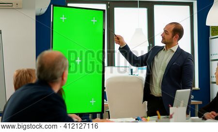 Young Man Leader Of Company Presenting Financial Strategy Using Green Screen Mockup Display In Front