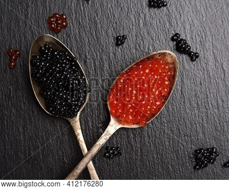 Black Caviar Of Paddlefish Fish And Red Chum Salmon Caviar In A Spoon, Black Background, Top View