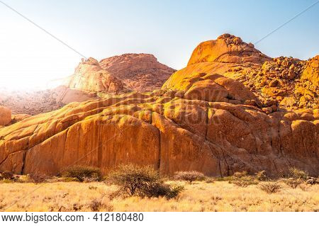 Pontok Mountains Near Spitzkoppe. Red Vivid Granite Rock Formation In Namib Desert At Sunset Time, N