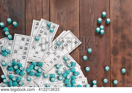 Many Barrels With Numbers And Cards For Lotto Or Russian Bingo Table Game On Wooden Surface. Russian