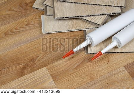 Set Of Items For Pvc Ceiling Indoor Works. Assembly Adhesive Bottles And Pvc Panels. Indoor Vpc Sidi