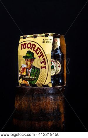 6 Pack Of Birra Moretti Beer On Wooden Barrel With Dark Background. Illustrative Editorial Photo Buc