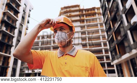 Topic Is Health Protection In Production And Construction. Caucasian Male Worker In Orange Uniform A