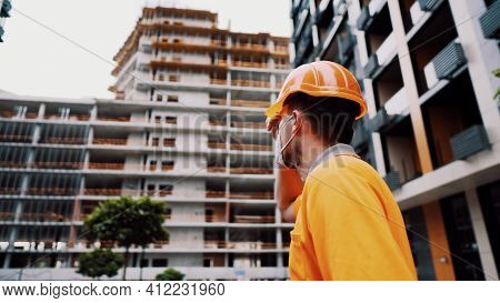 Topic Is Health Protection In Production And Construction. Caucasian Male Worker In Orange Uniform A