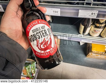 Belgrade, Serbia - March 2 2021: Hands Holding A Bottle Of Greene King Douple Hop Monster Ipa Beer. 