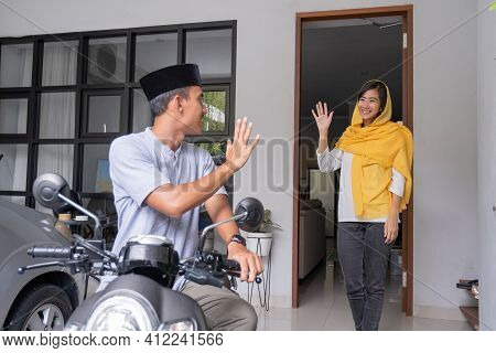 Asian Husband Waving Goodbye To His Wife Before Leaving Out By Motorcycle