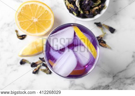 Glass Of Organic Blue Anchan With Lemon And Ice On White Marble Table, Flat Lay. Herbal Tea
