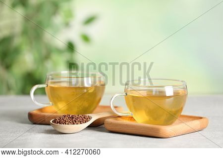 Cups Of Buckwheat Tea And Granules On Table Against Blurred Background. Space For Text