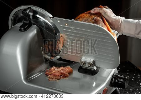 Slicing Hamon On Cutting Machine. Iberian Ham Cutter On Black Background.