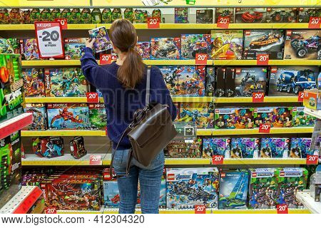 Woman Chooses Gift For A Child. Large Selection Of Toys In Toy Section Of A Hypermarket. Minsk, Bela