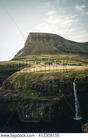 Gasadalur Village And Mulafossur Its Iconic Waterfall During Sunset In Summer With Bluw Sky. Vagar, 