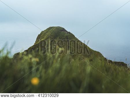 Kalsoy Island With Kallur Lighthouse On On Faroe Islands, Denmark, Europe. Clouds Over High Cliffs, 