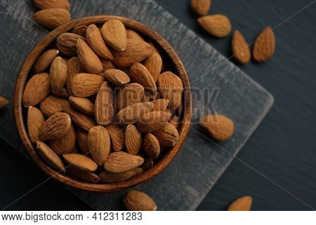 Almonds Nuts Close-up In A Cup On A Black Shabby Chic Board On A Black Schiffer Blurred Background.n