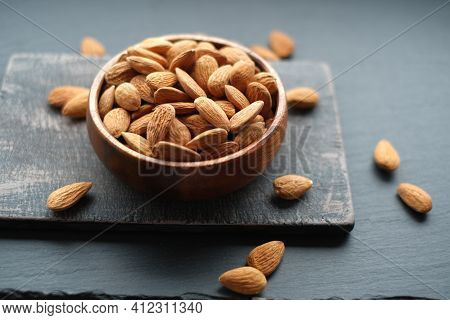 Almonds Nuts Close-up In A Cup On A Black Shabby Chic Board On A Black Schiffer Blurred Background.n