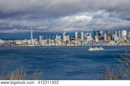 A Ferry Moves Across Elliott Bay In Front Of Skyscrapers In Seattle, Washington.