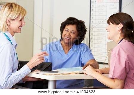 Arzt und Krankenschwestern In Diskussion an Krankenschwestern Station