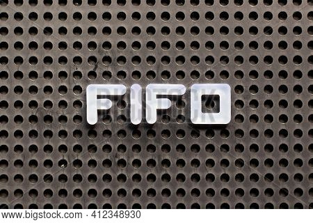White Color Letter In Word Fifo (abbreviation Of First In First Out) On Black Pegboard Background