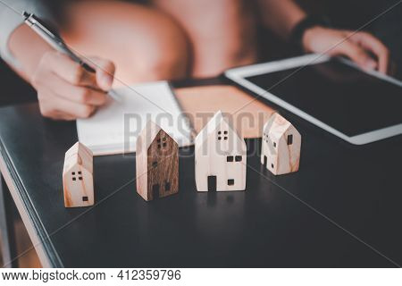 Wooden Toy House Medel With Woman Plan To Sign A Contract To Buy A House, Real Estate Concept.