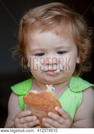 Cute Baby With Bread In Her Hands Eating. Cute Toddler Child Eating Sandwich, Self Feeding Concept. 