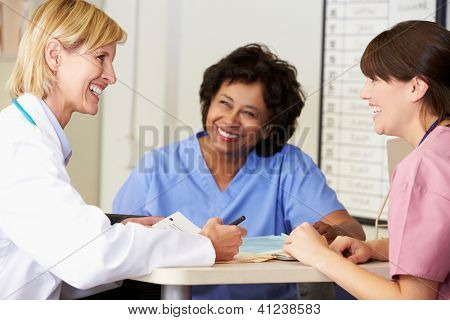Arzt und Krankenschwestern In Diskussion an Krankenschwestern Station