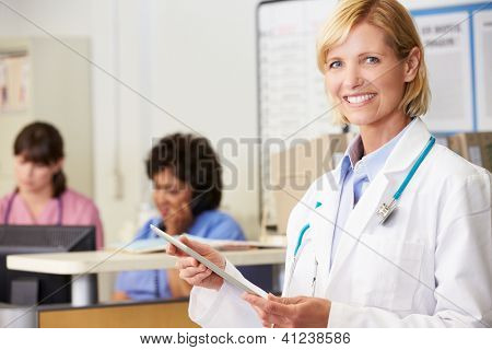 Ärztin, die mit digitalen Tablet bei Krankenschwestern Station