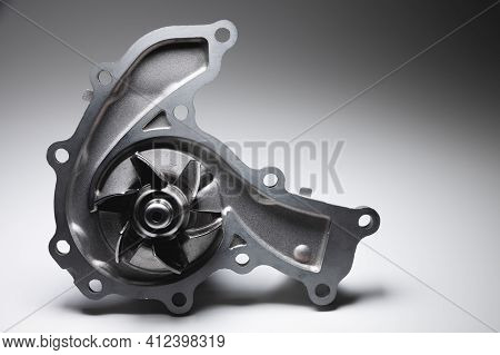 Close-up Of A New Internal Combustion Engine Cooling Water Pump On A Gray Background. Contrast Light