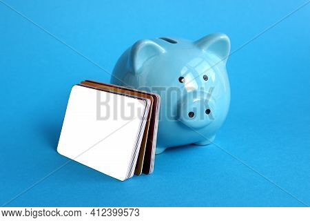 Blue Piggy Bank Pig Stands On A Blue Background With Credit Cards
