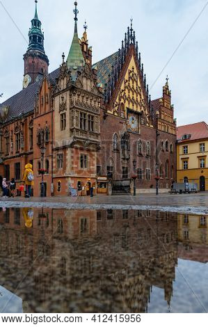 Wroclaw, Poland - May 23 2020: Town Hall Building At Market Square Reflected In Puddle