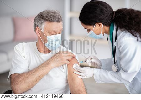 Immunizing Homebound Patients With Covid-19 Vaccine. Young Doctor Giving Injection Against Covoravir