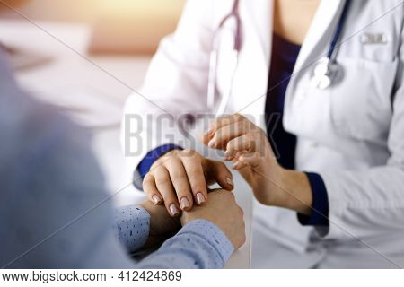 Unknown Woman-doctor Is Holding Her Patients Hands To Reassure The Patient, Discussing Current Healt