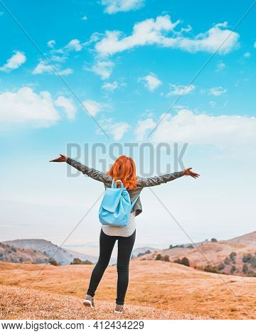 Beauty Woman Outdoors Enjoying Nature. Image Of A Girl In A Field Standing In The Distance With Her 