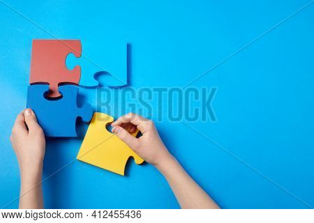 Top View Hands Of A Autistic Child Arranging Color Puzzle Symbol Of Awareness For Autism Spectrum Di