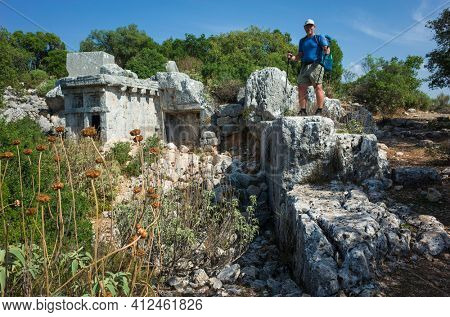 Hiking Lycian way. Man is standing on ruins of ancient city of Phellos on Lycian way trail, Trekking in Turkey, outdoor activity in sunny day
