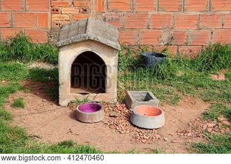 A Doghouse Made Of Stone And A Bowl. Empty Doghouse.