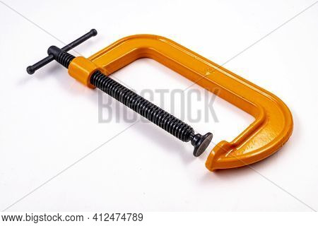 Carpenter's Clamp Used In A Carpentry Shop. Metal Joinery Accessories. Light Background.