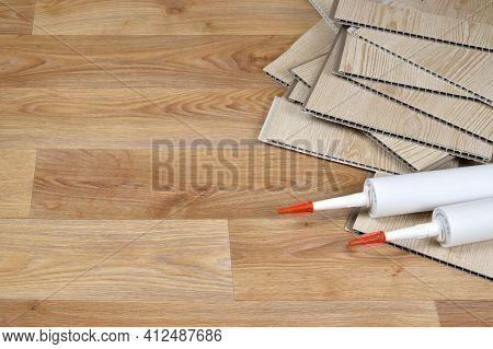Set Of Items For Pvc Ceiling Indoor Works. Assembly Adhesive Bottles And Pvc Panels. Indoor Vpc Sidi