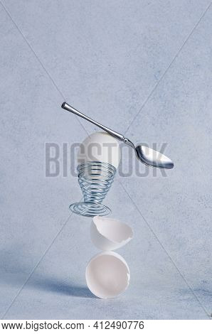 Balancing Breakfast. Stable Balancing Structure Of Boiled Egg, Egg Shell And Dessert Spoon.