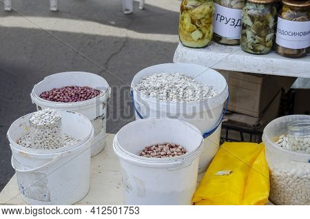 Different Varieties Of Dry Beans On The Counter Of The Local Market. Canned Wild Mushrooms In The Ba