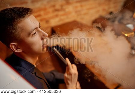 Young man smokes in hookah bar, hooka chill out