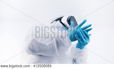 African American Black Doctor In Protective Uniform And With Vr Glasses Putting On Gloves. High Qual