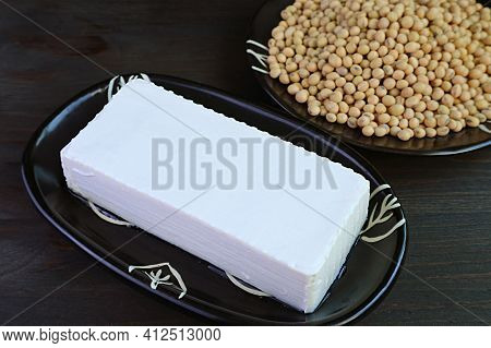Closeup Of A Soft Tofu Bean Curd With Blurry Dried Soybeans Pile In Background