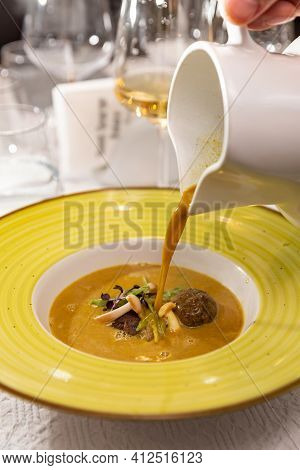 Cream Soup With Meatballs And Pork Jowl Decorated With Enoki Mushrooms