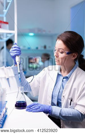 Scientist Looking Into Micropipette For Biology Test . Woman Research A New Experiment In Modern Lab