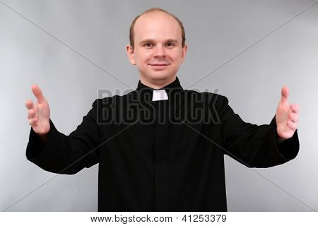Giovane sacerdote su sfondo grigio