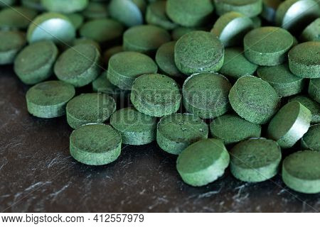 Spirulina Green Pills On Dark Slate Plate