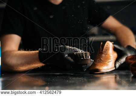 Close-up Of Unrecognizable Man In Black Latex Gloves Cleaning Shoe Brush, Brushing Dust And Dirt Off