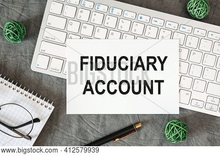 Fiduciary Account Is Written In A Document On The Office Desk With Office Accessories.