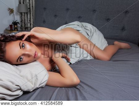 Adult Woman Enclosing The Bedspread With Her Naked Leg